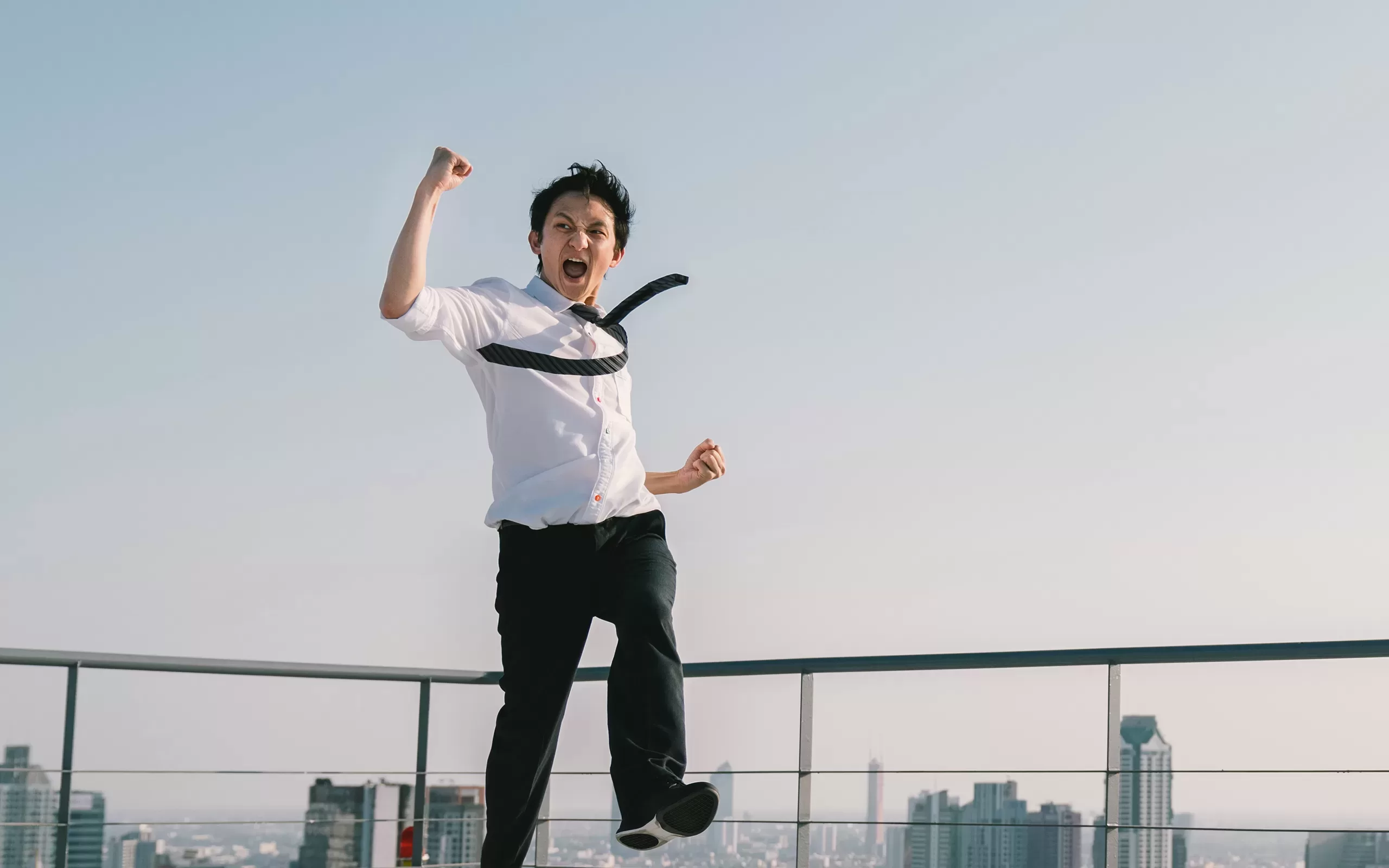 Homme japonais en chemise cravate sautant en l'air